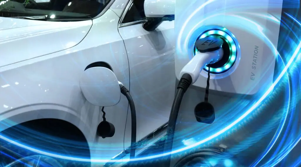 A white electric car, recharging at an electric vehicle charge point.