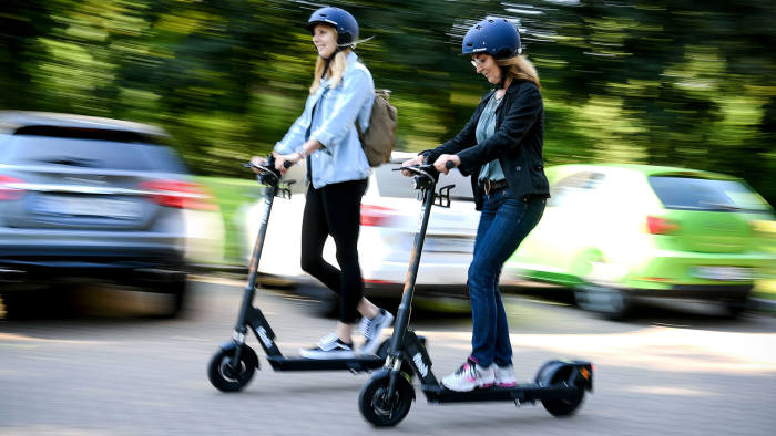 Two ladies riding electric scooters 