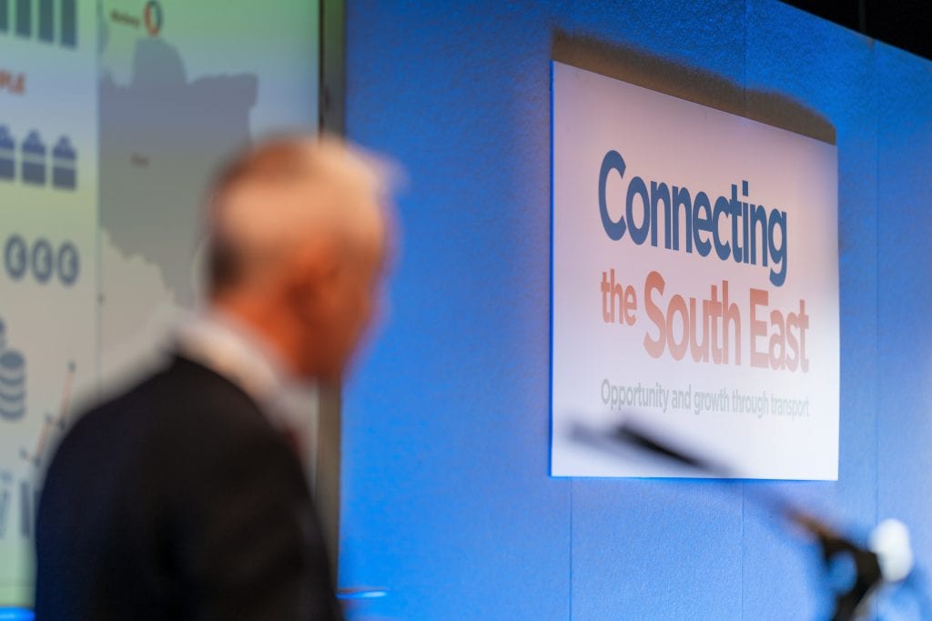 A picture of a man facing a sign that says 'Connecting the South East'
